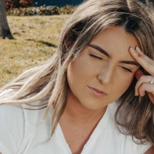 Mulher com enxaqueca durante consulta online de neurologia